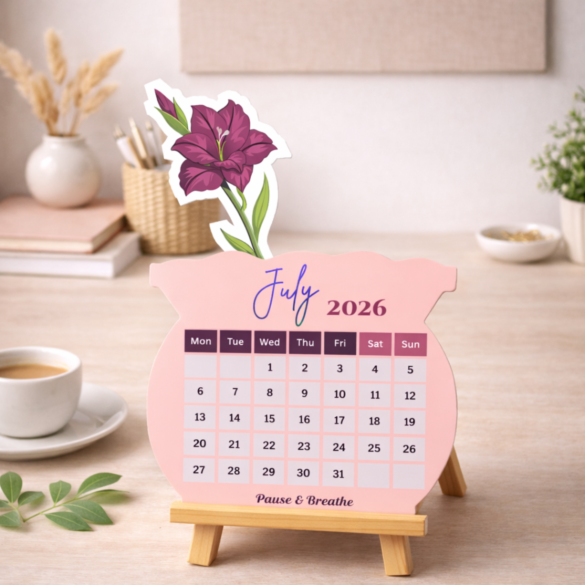 Desk calendar for July 2026 with a purple flower design on a wooden stand.